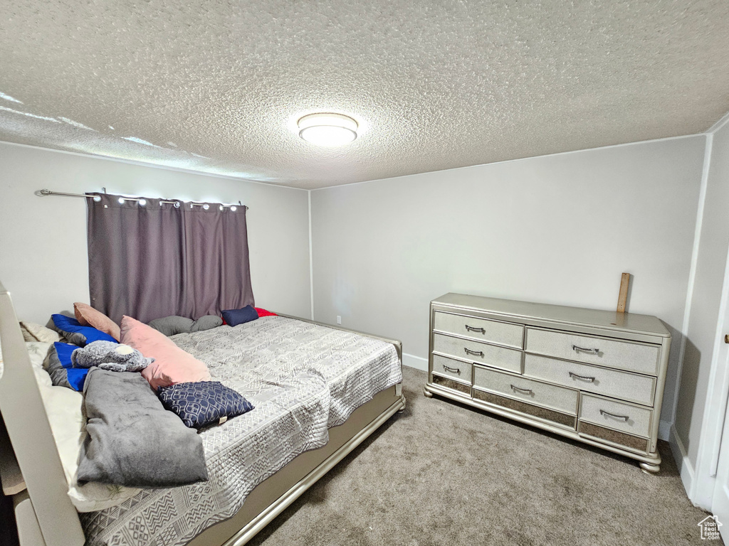 Carpeted bedroom featuring a textured ceiling