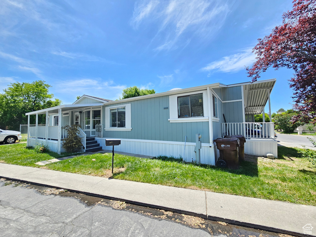 Manufactured / mobile home with a porch and a front lawn