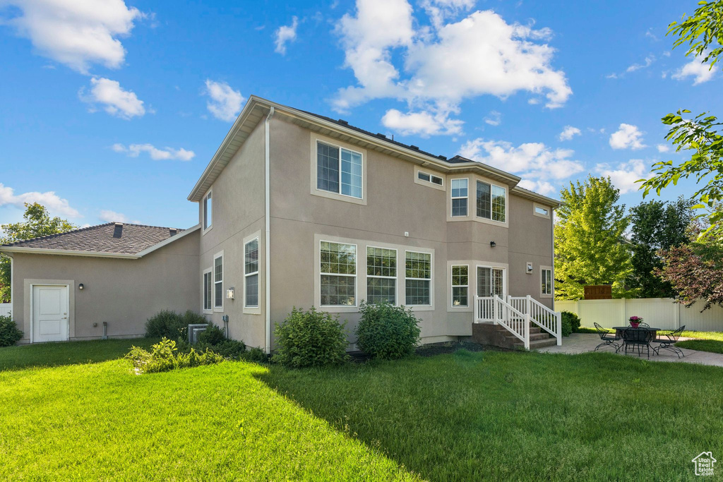 Rear view of house featuring stucco siding and a patio