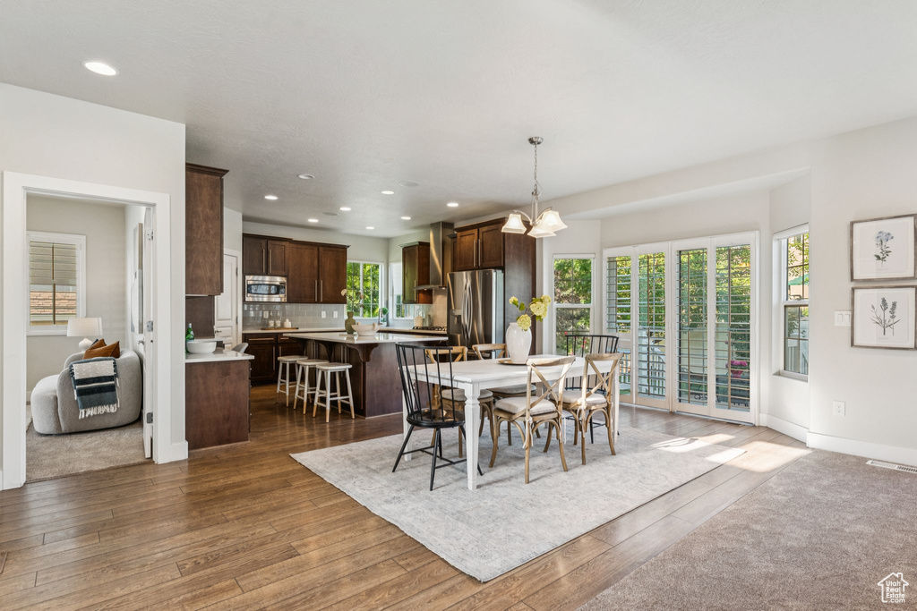 Dining area featuring dark wood finished floors, recessed lighting, baseboards, and a chandelier