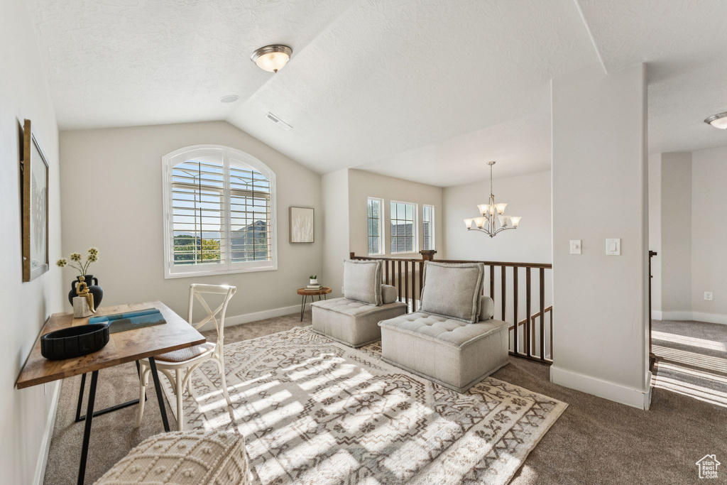 Sitting room with carpet flooring, a chandelier, lofted ceiling, baseboards, and an upstairs landing
