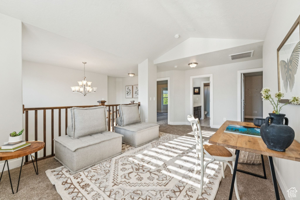 Carpeted living room featuring lofted ceiling and a chandelier