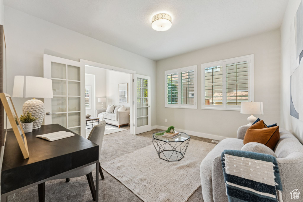 Carpeted home office featuring baseboards and french doors