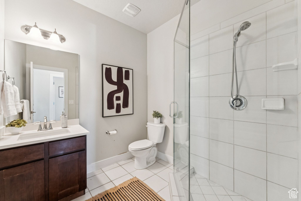 Full bathroom featuring vanity, a stall shower, toilet, and baseboards
