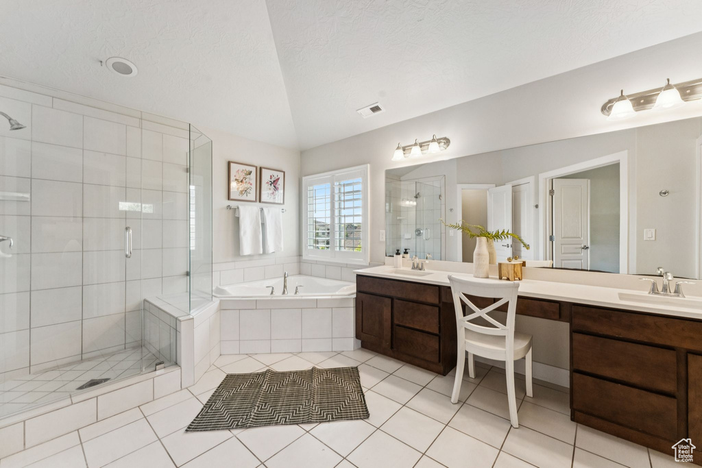 Bathroom with lofted ceiling, double vanity, a stall shower, a garden tub, and tile patterned flooring
