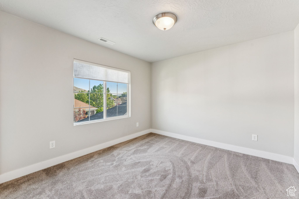 Unfurnished room with carpet flooring and baseboards