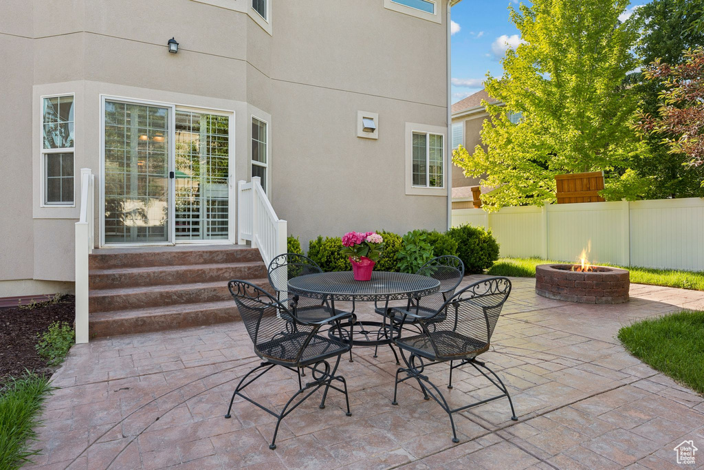 View of patio featuring a fire pit, entry steps, and outdoor dining area