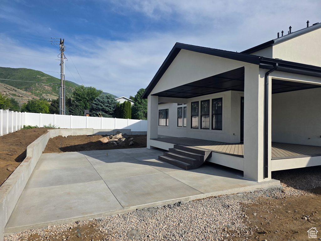 View of home's exterior with stucco siding, a mountain view, metal roof, a patio area, and a standing seam roof