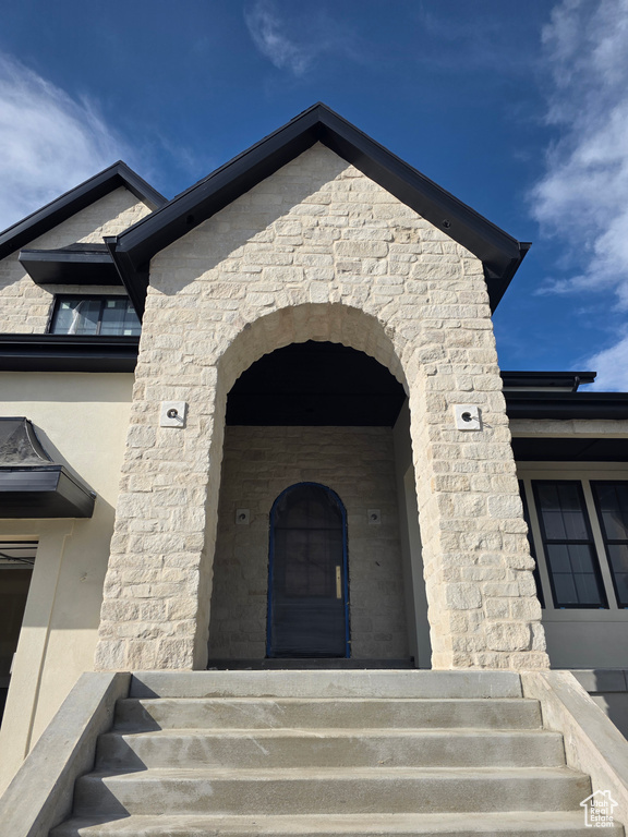 Property entrance with stone siding and stucco siding