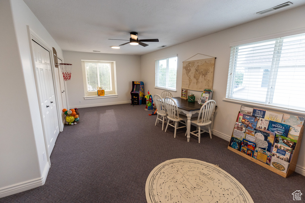 Recreation room featuring a ceiling fan, carpet floors, and baseboards