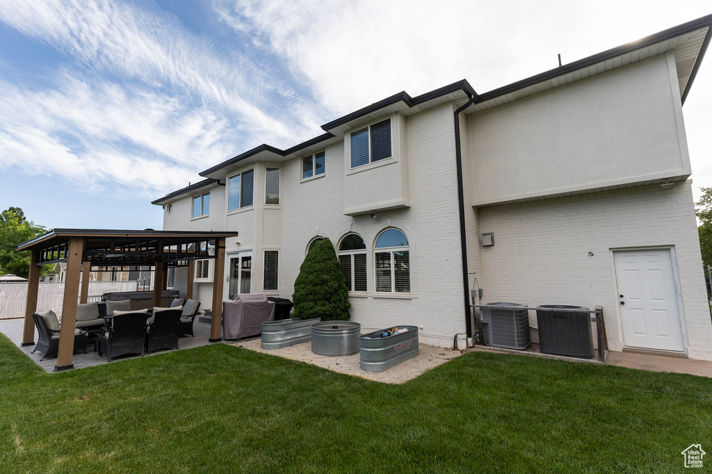 Rear view of house with a gazebo, an outdoor hangout area, central AC unit, and a patio area
