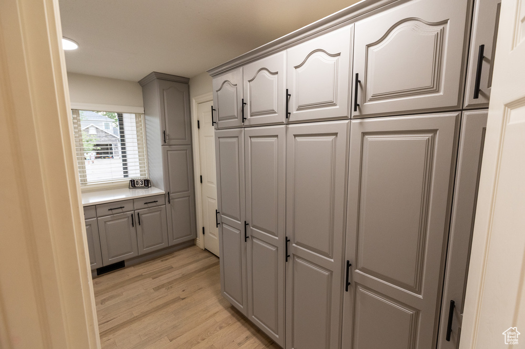 Kitchen with gray cabinets, light wood-type flooring, and light countertops