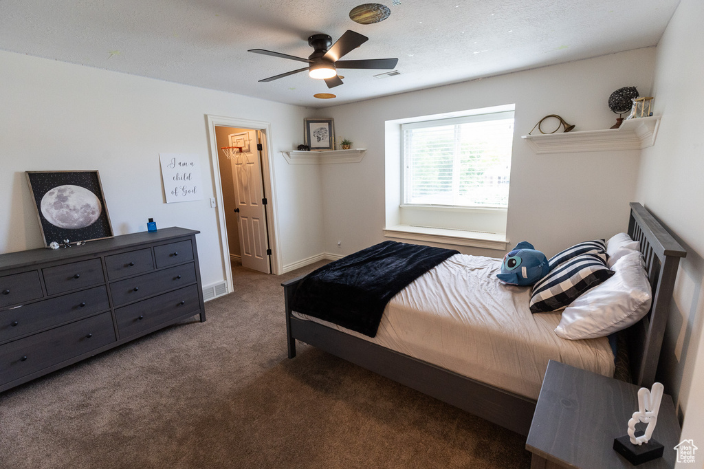 Carpeted bedroom with a ceiling fan and baseboards