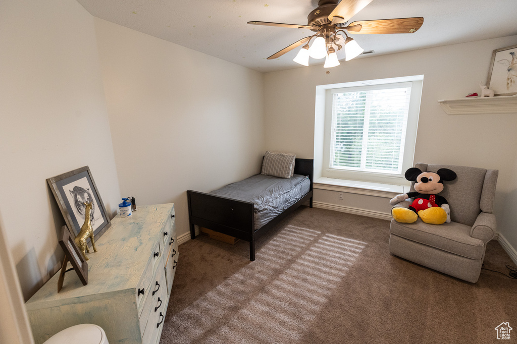 Bedroom featuring dark carpet, baseboards, and a ceiling fan