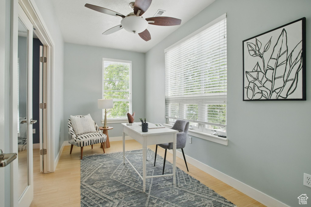 Office area with a ceiling fan, light wood finished floors, and baseboards