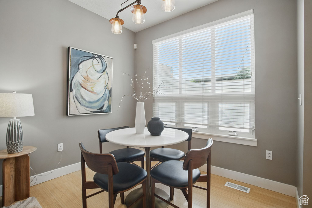 Dining room with baseboards, healthy amount of natural light, and light wood-style flooring