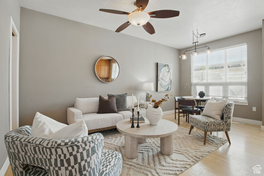 Living area featuring ceiling fan, light wood-style floors, and baseboards