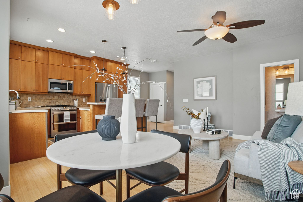 Dining space featuring a ceiling fan, recessed lighting, baseboards, and light wood-style flooring