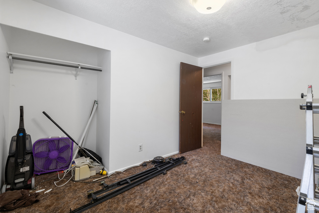 Unfurnished bedroom featuring carpet and a textured ceiling