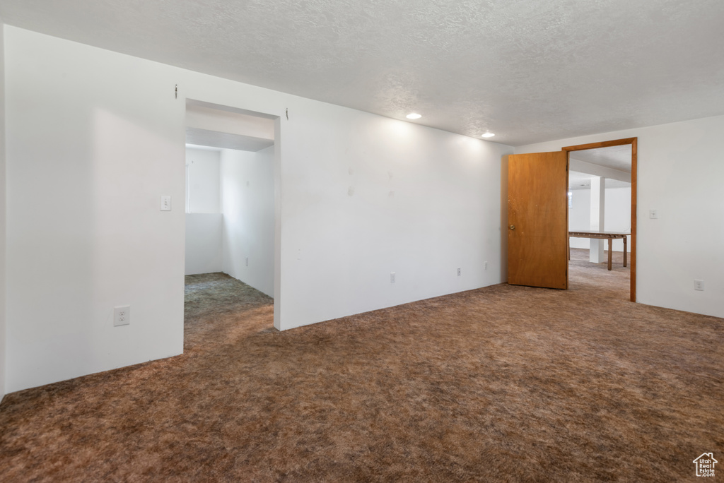 Empty room with carpet and a textured ceiling