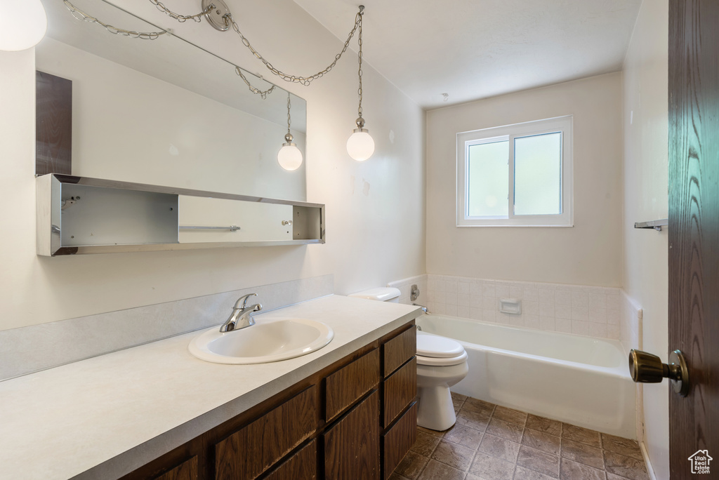 Bathroom featuring toilet, a tub, and vanity