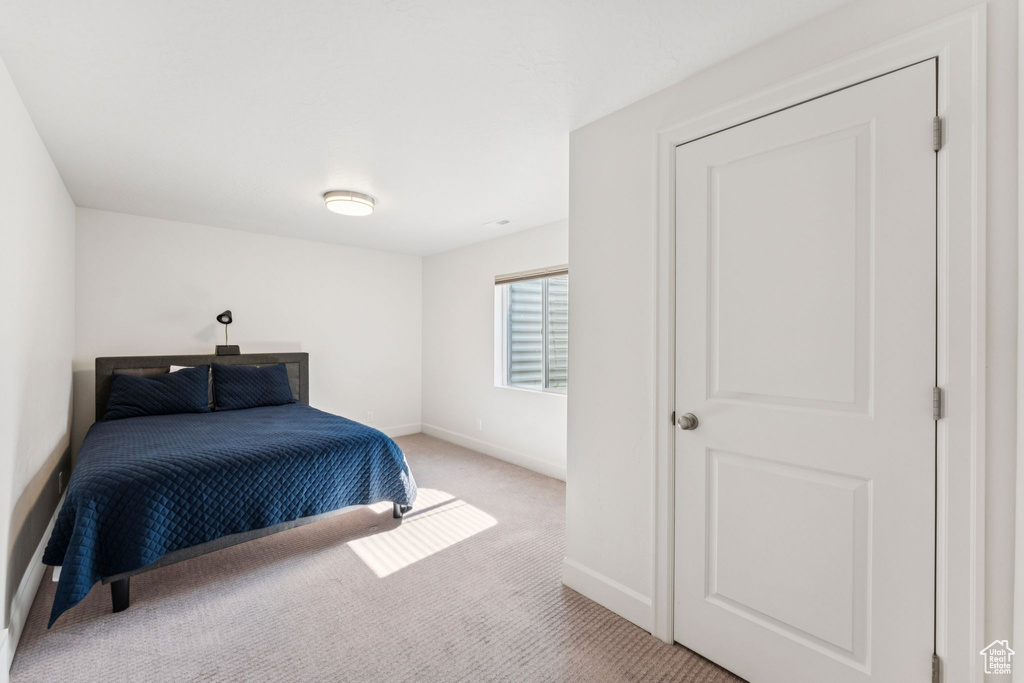 Bedroom featuring light colored carpet and baseboards