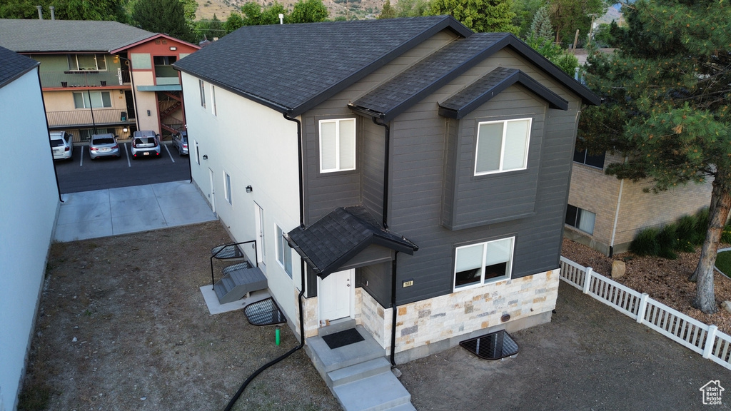 View of front of property featuring roof with shingles and stone siding