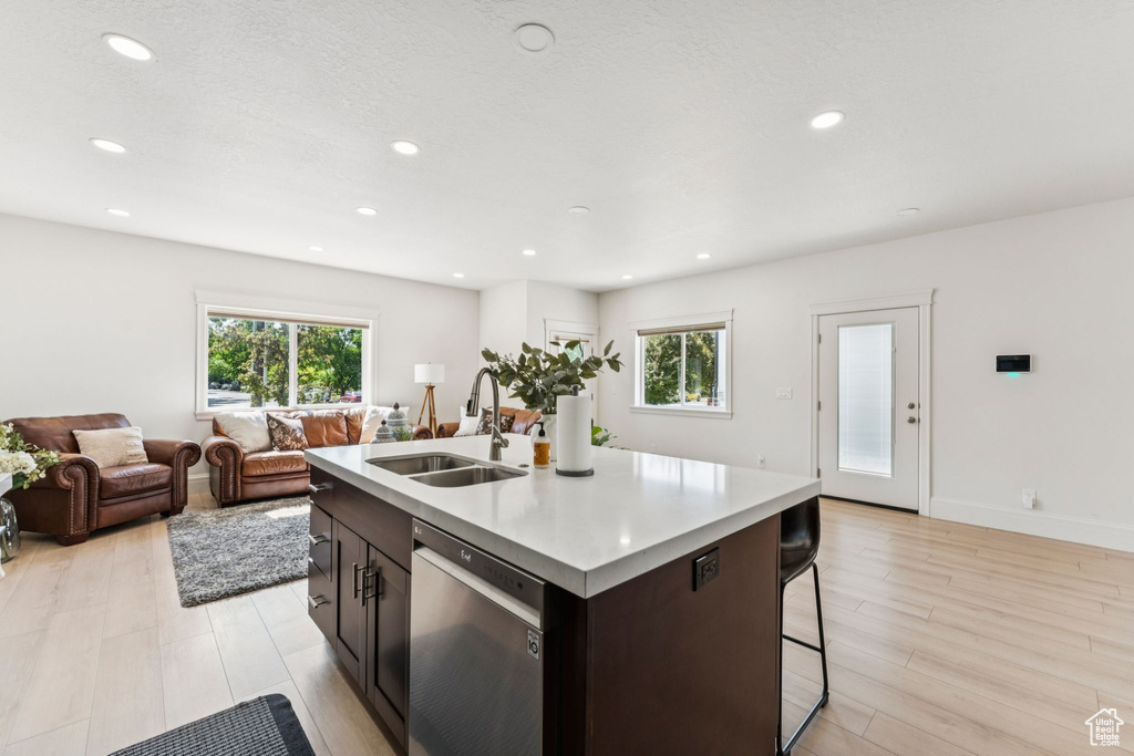 Kitchen with a sink, dishwasher, plenty of natural light, light countertops, and recessed lighting