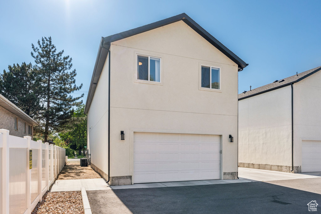 View of side of home featuring stucco siding and a garage