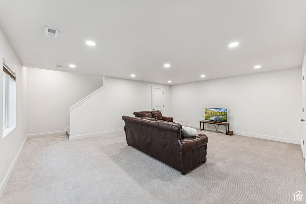 Living area with light colored carpet, recessed lighting, stairs, and baseboards