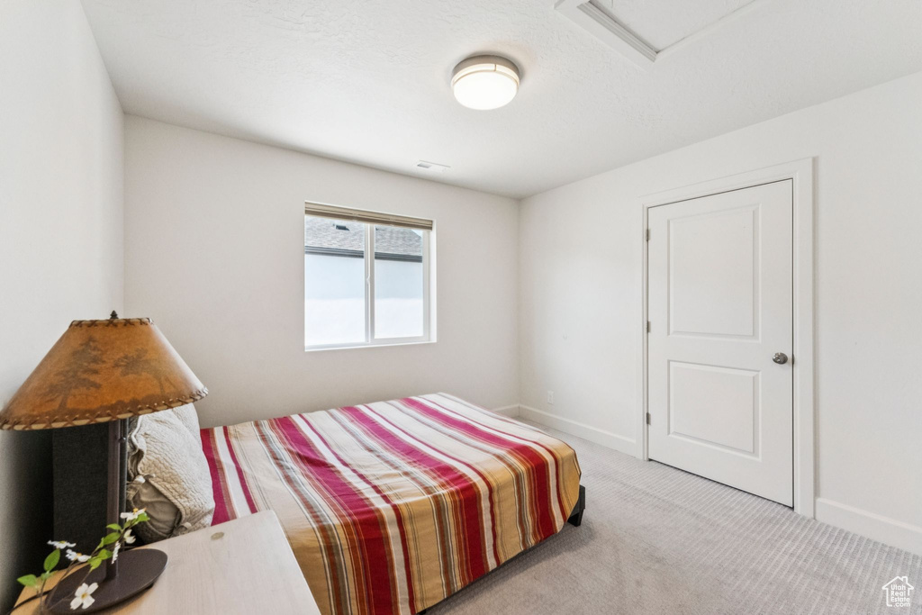 Bedroom with carpet flooring, attic access, and baseboards