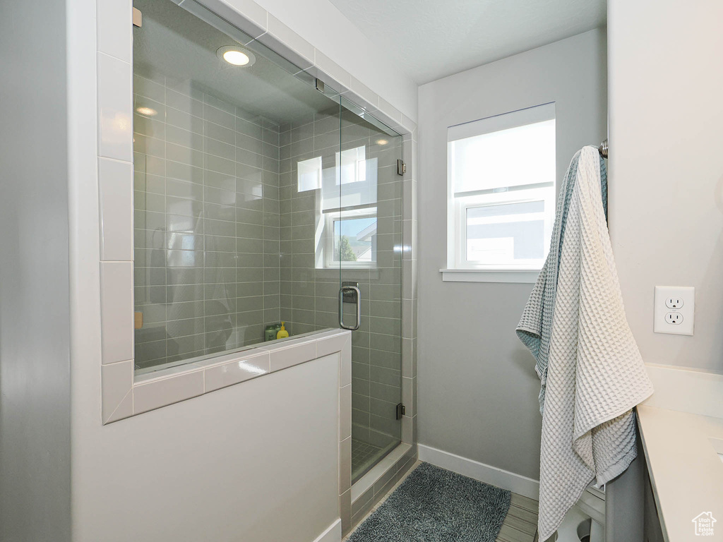 Full bathroom featuring baseboards, vanity, and a stall shower
