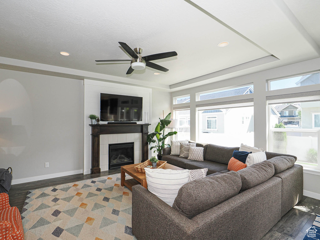 Living area featuring wood finished floors, baseboards, a tile fireplace, ceiling fan, and recessed lighting