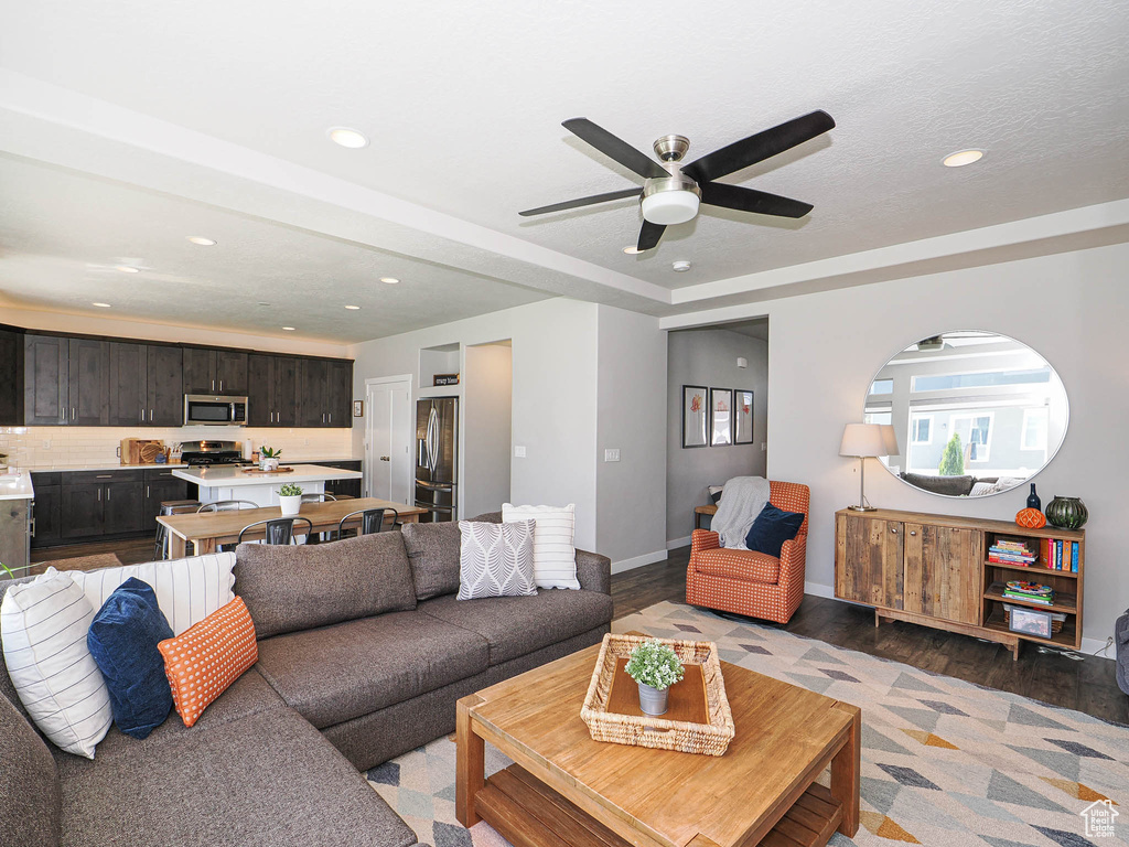 Living room with recessed lighting, light wood finished floors, a ceiling fan, and baseboards