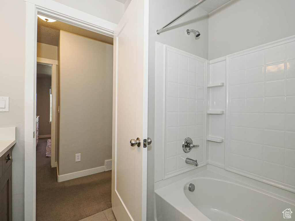 Full bathroom with vanity, bathtub / shower combination, and baseboards