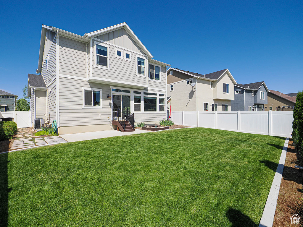Back of house featuring board and batten siding, central air condition unit, and a residential view
