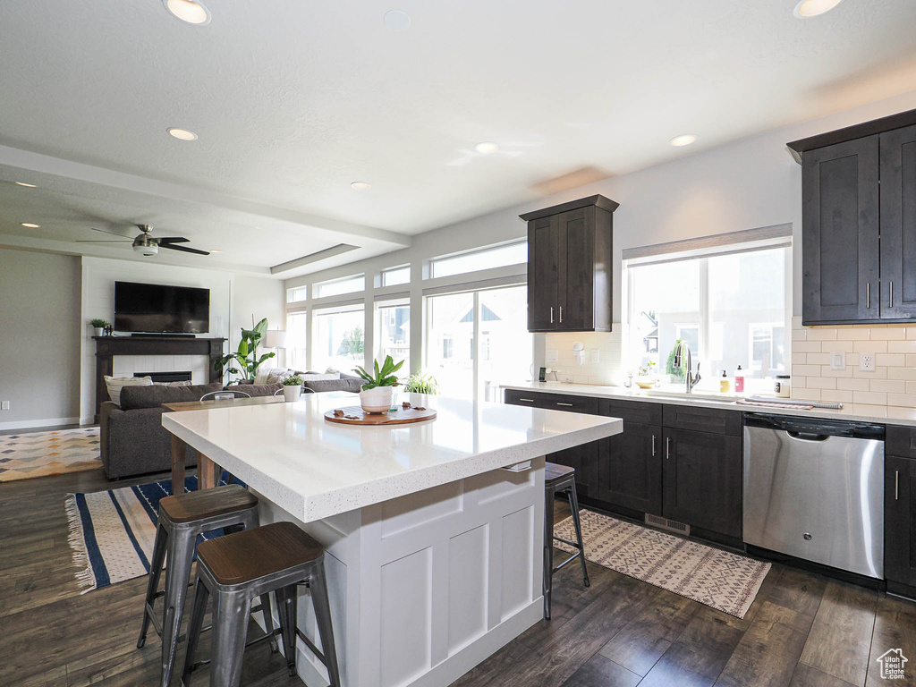 Kitchen featuring stainless steel dishwasher, a breakfast bar, a sink, ceiling fan, and recessed lighting