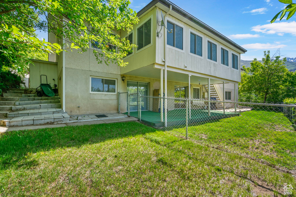 Rear view of house with a patio area, stairway, and stucco siding