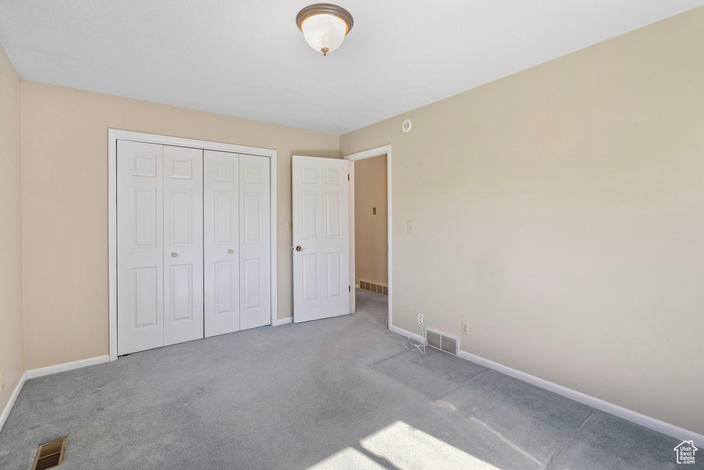 Unfurnished bedroom with carpet flooring, baseboards, and a closet