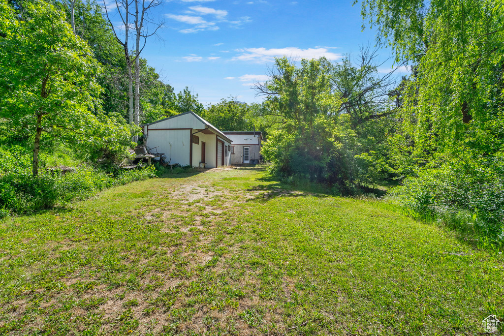 View of green lawn with a garage