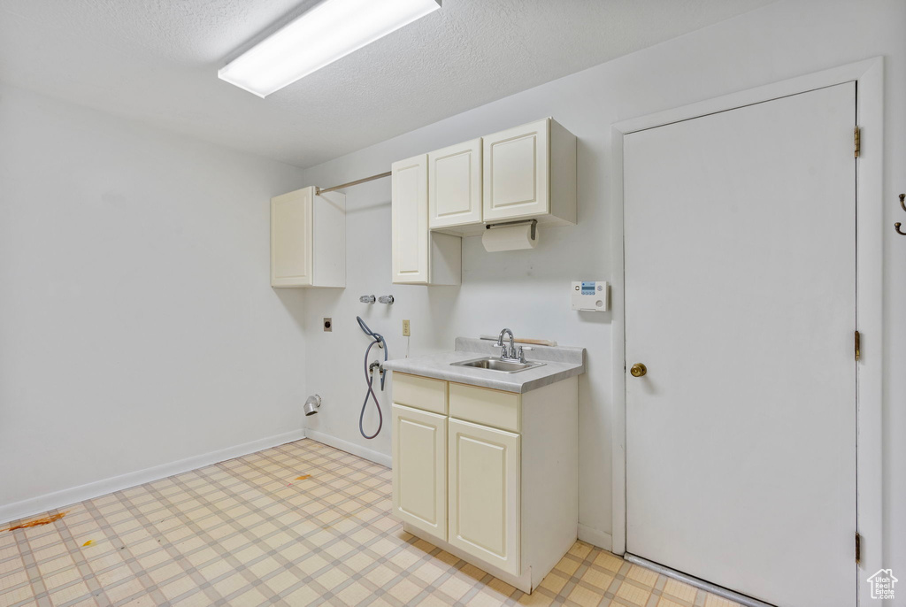 Laundry room with light floors, hookup for an electric dryer, cabinet space, washer hookup, and hookup for a gas dryer