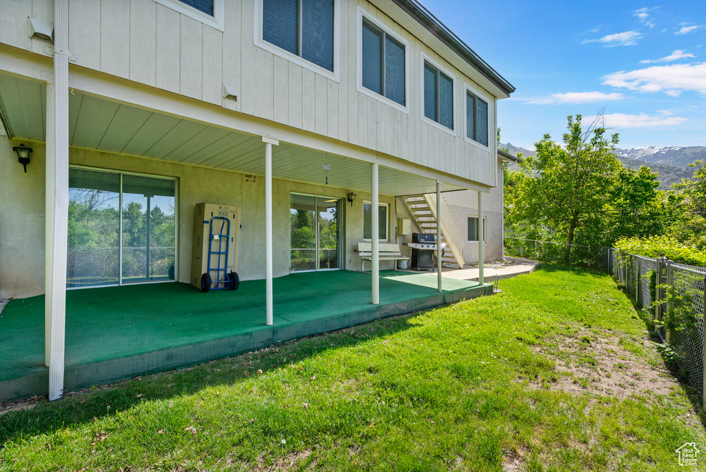Rear view of house with stairs, a patio area, and a mountain view