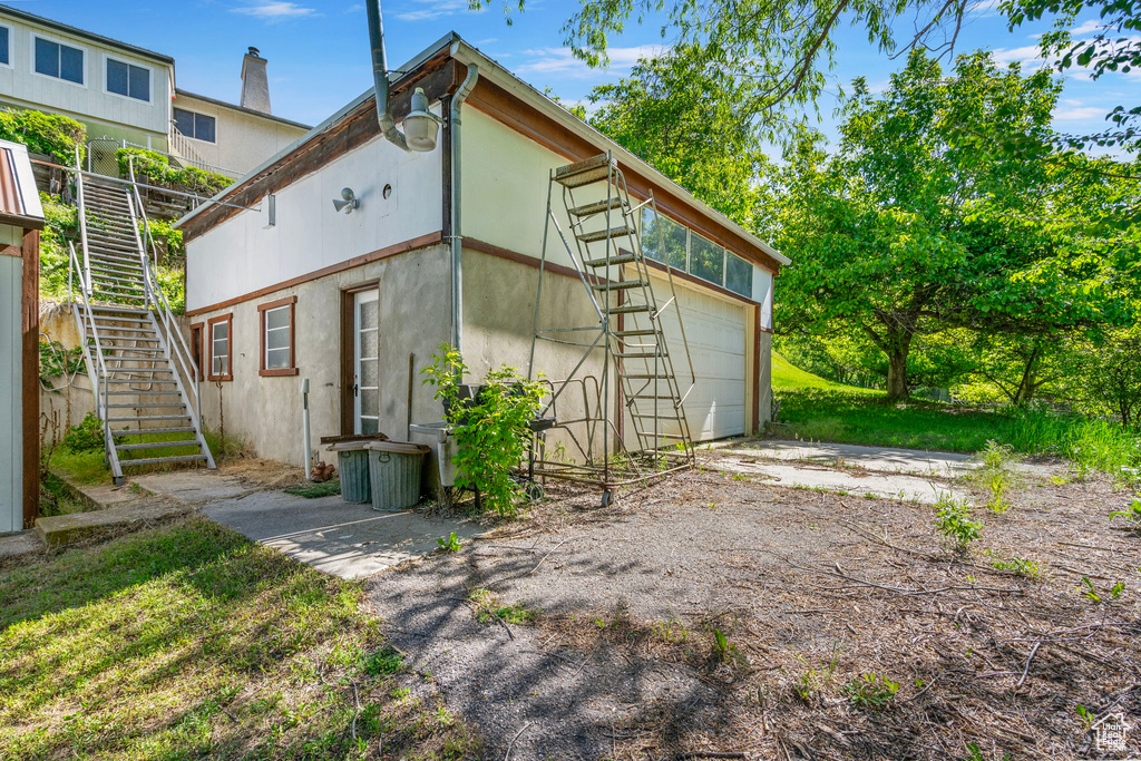 Rear view of property with stairs and stucco siding