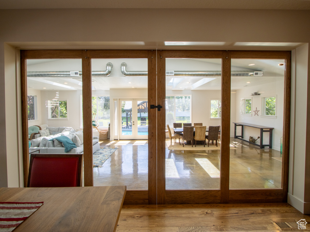 Doorway to outside featuring french doors, healthy amount of natural light, and baseboards