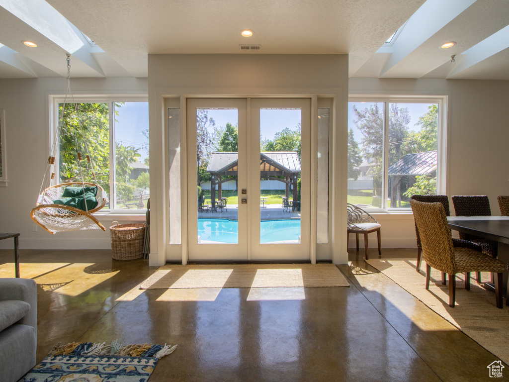 Entryway featuring a skylight, finished concrete floors, french doors, and recessed lighting
