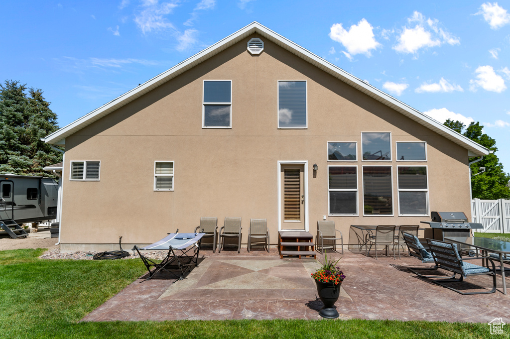 Back of property with stucco siding, entry steps, and a patio area