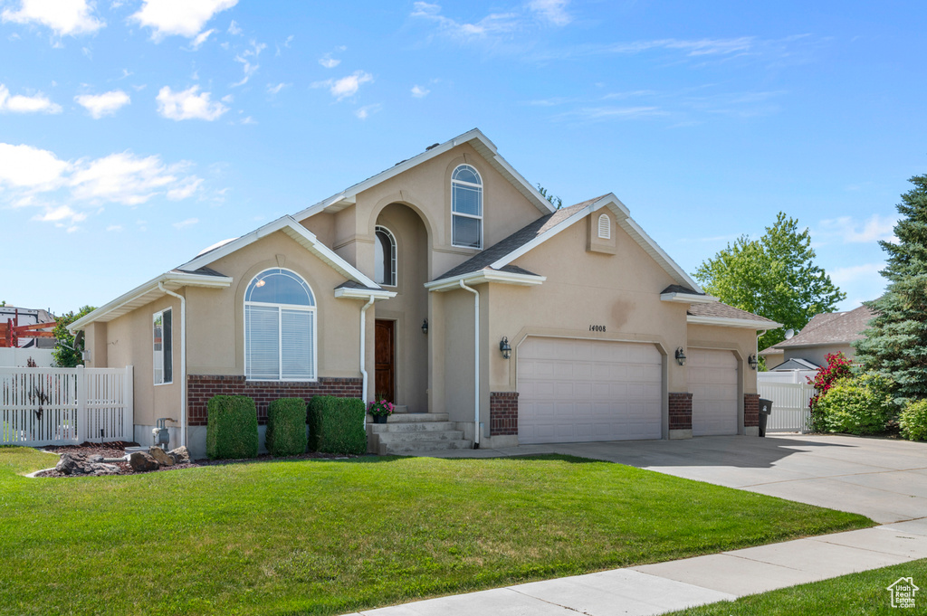 View of front facade featuring concrete driveway, stucco siding, a garage, and brick siding