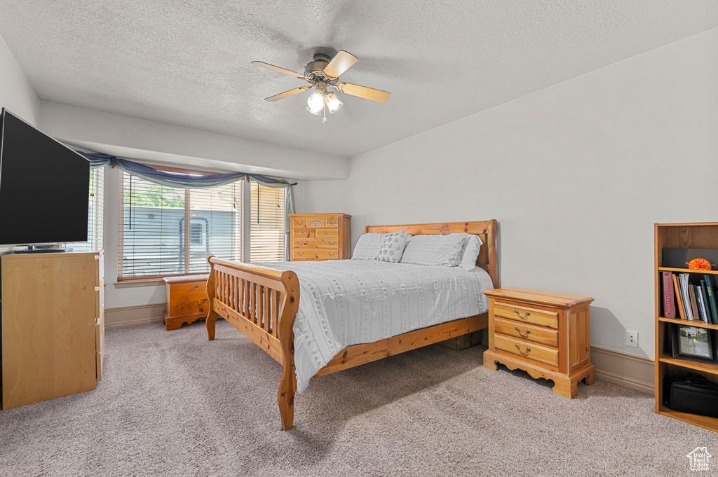 Bedroom with carpet flooring, a textured ceiling, ceiling fan, and baseboards