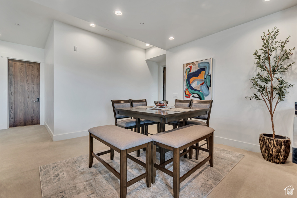 Dining area with light carpet, baseboards, and recessed lighting