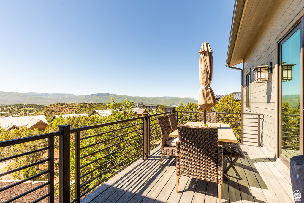Wooden deck with a mountain view and outdoor dining space
